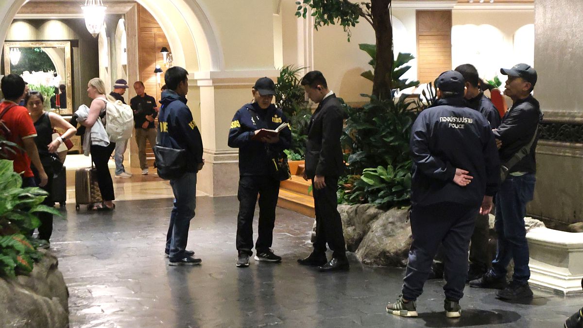 Polis memurları Bangkok, Tayland'daki Grand Hyatt Erawan Otel'de bir personelle konuşuyor