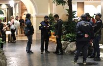 Police officers talk to a staff member at the Grand Hyatt Erawan Hotel in Bangkok, Thailand