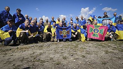 Photographie diffusée le 17 juillet 2024 montrant des prisonniers de guerre ukrainiens posant à la suite d'un échange dans un lieu non précisé en Ukraine.