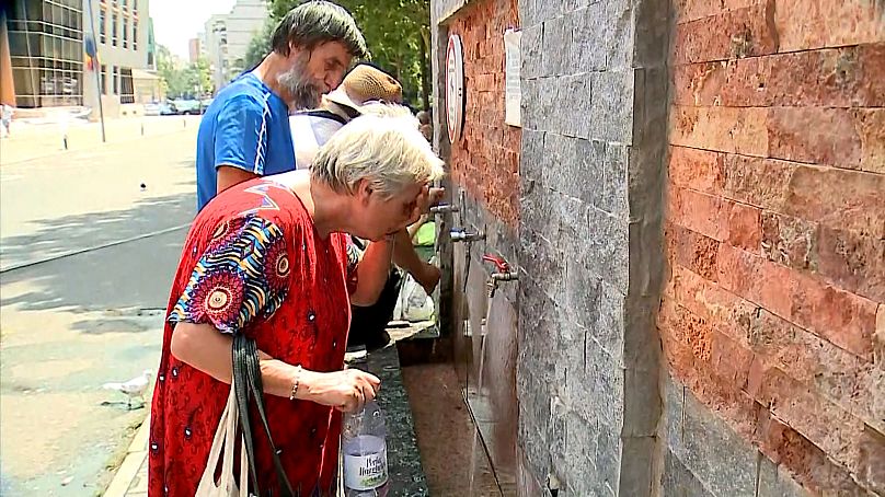 Une habitante de Bucarest se rafraîchit à une fontaine