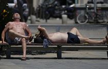 Deux personnes prennent un bain de soleil sur sur une plage de Barcelone