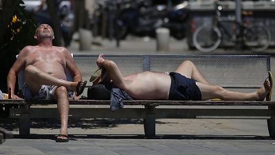 Deux personnes prennent un bain de soleil sur sur une plage de Barcelone