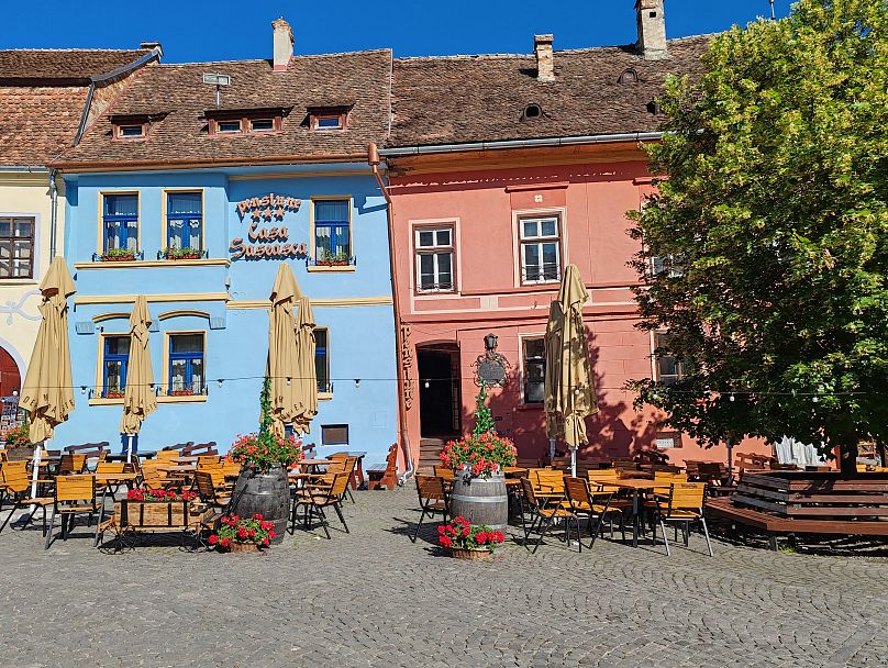 In Sighisoara, narrow cobbled streets and wide squares are lined with pale blue, peach and yellow houses. 