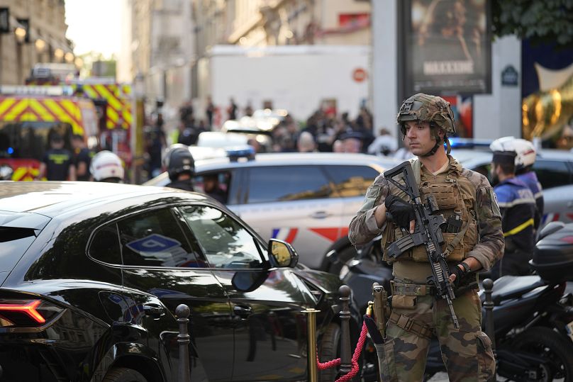 A soldier stands guard near the Champs-Élysées avenue after a stabbing, July 18, 2024