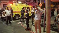 People gather at the scene of an deadly explosion in Tel Aviv, Israel, early on Friday