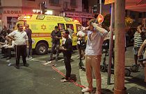 People gather at the scene of an deadly explosion in Tel Aviv, Israel, early on Friday