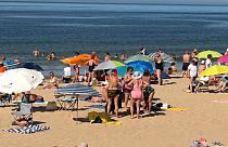 Portuguese citizens flock to the beach in Lisbon during heatwave.