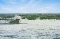 Um homem a fazer surf em águas brasileiras