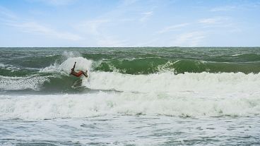 Un homme surfe dans les eaux brésiliennes