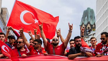 Türk taraftarlar, Euro 2024 çeyrek finalinin başlamasından önce taraftar yürüyüşü sırasında, kökeni aşırı sağcı bir harekete atfedilen 'kurt selamı' veriyor 
