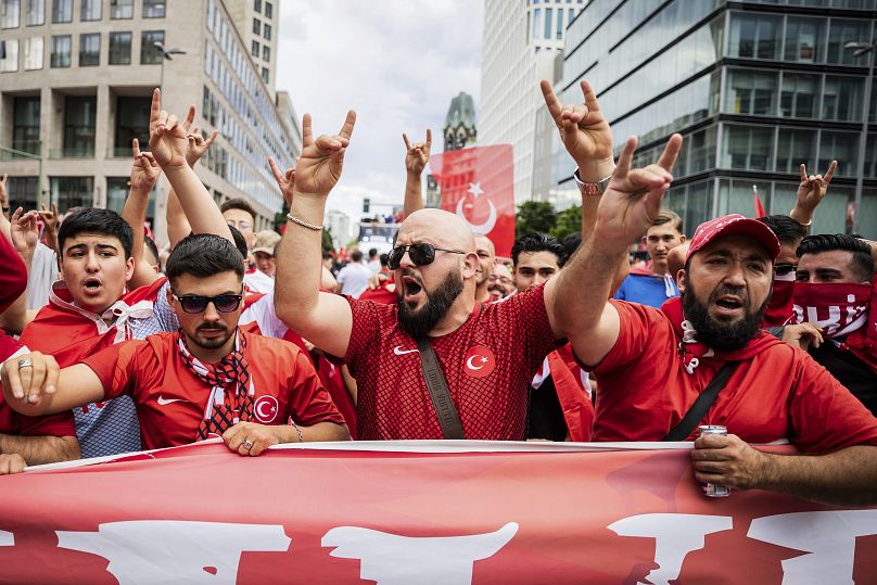 Turkey fans show the 'wolf salute', the origin of which is attributed to a right-wing extremist movement, during a fan walk before the start of the Euro 2024 quarterfinal 