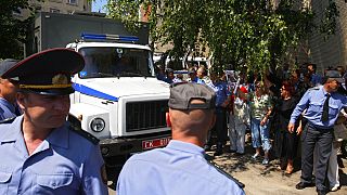 ARCHIVO - Agentes de policía frente al edificio de los tribunales en la ciudad de Grodno, Bielorrusia, martes 14 de junio de 2011. 