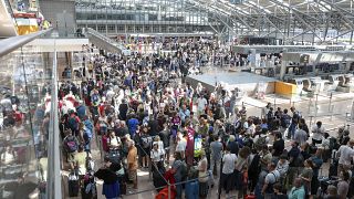 Ταξιδιώτες περιμένουν στον Αεροσταθμό 1 για check-in στο αεροδρόμιο του Αμβούργου μετά τη διακοπή της πληροφορικής που προκάλεσε χάος στα ταξίδια, 19 Ιουλίου 2024