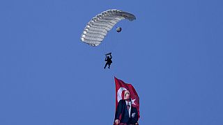 Ein türkischer Fallschirmspringer schwebt mit einer türkischen Flagge und einem Porträt von Atatürk über die Militärparade im türkisch besetzten Teil Nikosias, 20. Juli 2024.