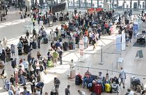 Utazók várakoznak az 1-es terminálon az utasfelvételre a hamburgi repülőtéren, 2024. július 19.