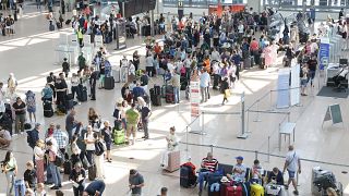 Yolcular Hamburg Havalimanı'nda check-in yapabilmek için sıra bekliyor, 19 Temmuz 2024