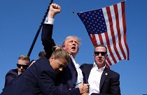 Trump, 13 Temmuz 2024'te Butler, Pennsylvania'daki bir kampanya mitinginde düzenlenen suikast girişiminin ardından ABD Gizli Servis ajanları ile görüntüleniyor.
