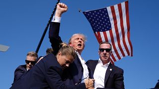Trump, 13 Temmuz 2024'te Butler, Pennsylvania'daki bir kampanya mitinginde düzenlenen suikast girişiminin ardından ABD Gizli Servis ajanları ile görüntüleniyor.