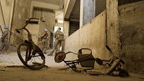 Peacekeepers stand behind two kids’ bicycles inside of an abandoned building inside the UN controlled buffer zone in the central of the divided capital Nicosia, 6 June 2024