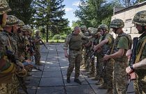 Ukrán katonai oktató ellenőrzi besorozott foglyok fegyvereit