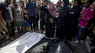 Abitanti di Gaza davanti a corpi senza vita