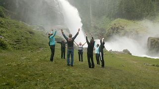 Visitantes fazem exercícios junto à cascata de Krimml