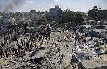 Filistinliler Gazze Şeridi'nin güneyindeki Han Yunus'ta İsrail bombardımanının ardından bölgedeki hasarı inceliyor, 13 Temmuz 2024.