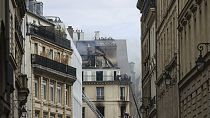 I vigili del fuoco lavorano in una stradina dopo un incendio scoppiato in un condominio, sabato 20 luglio 2024, nel centro di Parigi, in Francia. (Foto AP/Thomas Padilla)