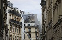 Firefighters work in a tiny street after a fire has broken out in an apartment building, Saturday, July 20, 2024, in the center of Paris, France. (AP Photo/Thomas Padilla)