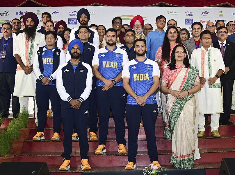 Indian athletes posing with officials as they model India's ceremonial and playing uniforms for the Paris Olympics in New Delhi, India, 30 June 2024.