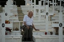 لوكاس ألكسندرو، 94 عامًا، يجلس بجوار قبر ابنه كريستاكيس الذي قُتل أثناء الغزو التركي، قبرص، الجمعة 19 يوليو 2024. 