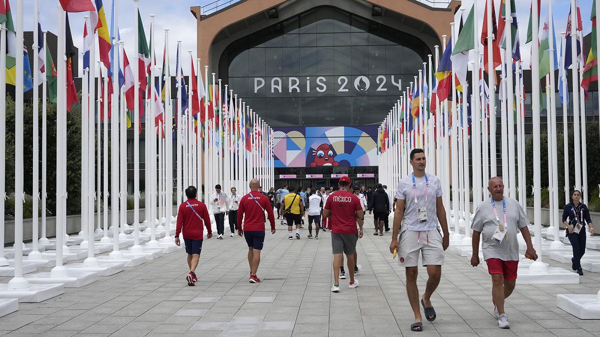 People walk in front of the canteen in the Olympic Village, at the 2024 Summer Olympics in Paris, 22 July 2024