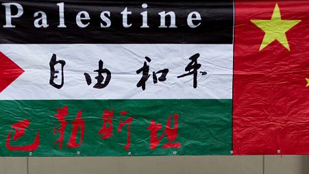 A Palestinian flag bearing the words "Free and Peace" hanging beside a Chinese national flag during a protest outside the Palestine Embassy in Beijing.