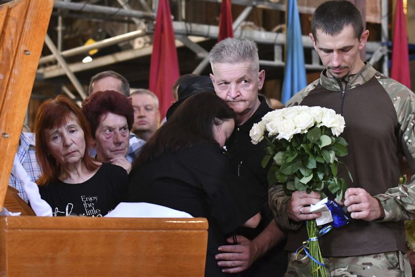 Relatives mourn at the coffin of former Ukrainian nationalist lawmaker Iryna Farion during a funeral ceremony in the Saints Peter and Paul church in Lviv, Ukraine