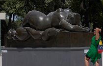 A woman poses for a picture near Fernando Botero's "Sleeping Venus" sculpture at Rome's Pincio Terrace.