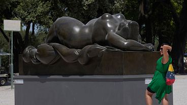 A woman poses for a picture near Fernando Botero's "Sleeping Venus" sculpture at Rome's Pincio Terrace.