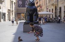 Egy római nő kutyájával Botero Macskája előtt