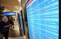 Passengers check a departures board at Phoenix Sky Harbor International Airport Friday, July 19, 2024, in Phoenix.