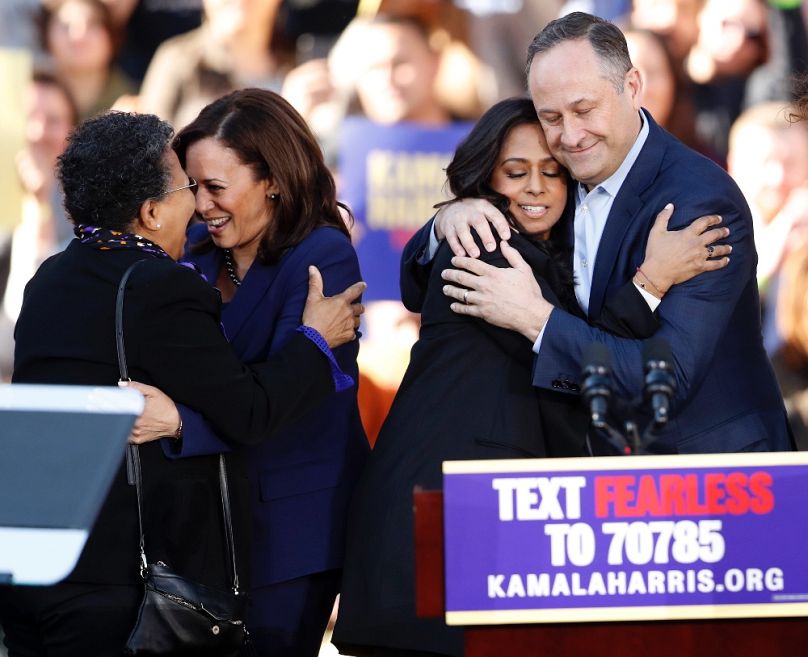 Kamala Harris egyik támogatójával, férje, Doug Emhoff pedig húgát, Maya Harrist öleli egy oaklandi kampányrendezvényen, 2019 januárjában