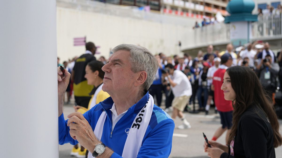 O Presidente do COI, Thomas Bach, assina o Monumento à Paz na Aldeia Olímpica, sede dos Jogos Olímpicos de verão de 2024, segunda-feira, 22 de julho de 2024, em Paris, França.