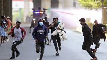 متظاهرون في العاصمة الكينية نيروبي يحاولون الفرار من قنابل الغاز التي أطلفتها الشرطة لتفريق المحتجين