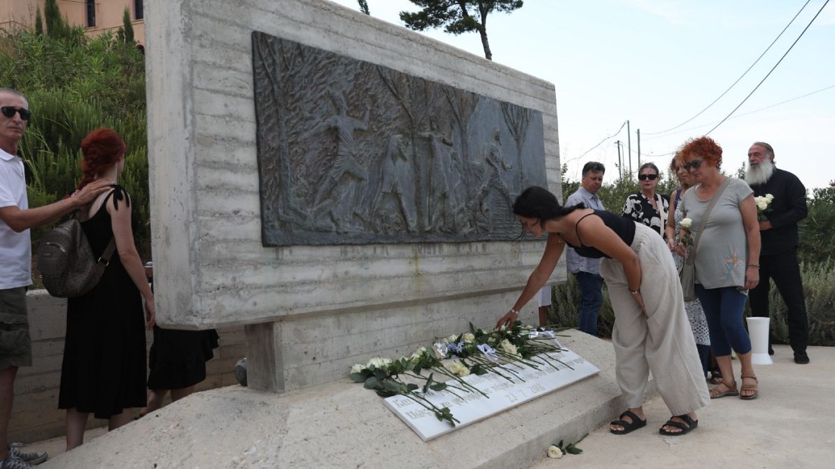 Συγγενείς και φίλοι των θυμάτων και πληγέντες από την καταστροφική πυρκαγιά στο Μάτι και τη Ραφήνα αφήνουν λουλούδια στο Μνημείο των θυμάτων της πυρκαγιάς