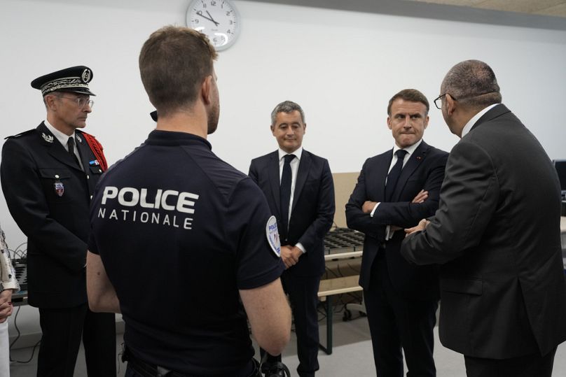 French President Emmanuel Macron, second right, listens to Paris police prefect Laurent Nunez, right, with French Interior Minister Gerald Darmanin as he visits the police.