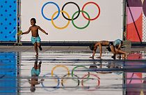 Des enfants s'amusent dans une fontaine près du logo des Jeux olympiques 2024, mardi 23 juillet, à Nice qui accueillera six matchs de foot.