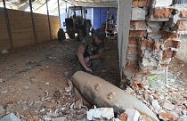A police officer inspects 250 kilogram (550 pound) unexploded bomb after Russian airstrike on farm warehouse of Bilyi Kolodiaz, Kharkiv region, Ukraine, Thursday, July 11.