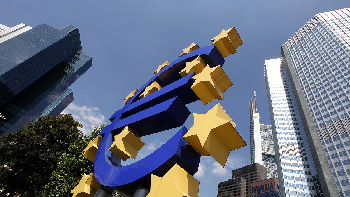 A man walks past a Euro sign in the hallway of the European Central Bank in Frankfurt, Germany