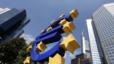 A man walks past a Euro sign in the hallway of the European Central Bank in Frankfurt, Germany