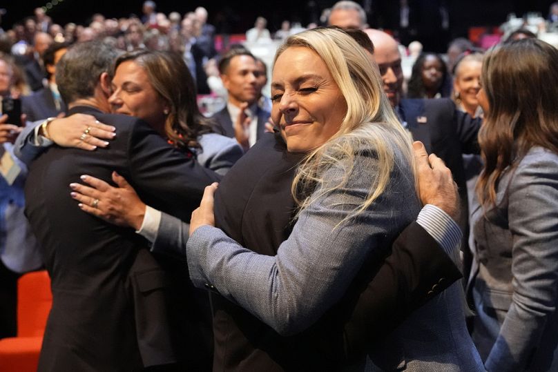 Former US skier Lindsey Vonn hugs members of the Salt Lake City delegation