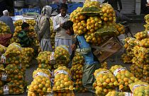  Un operaio trasporta sacchi di arance in un mercato all'ingrosso di frutta a Lahore, in Pakistan, il 1° dicembre 2021...