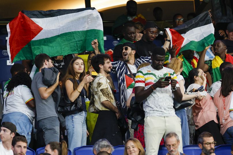 Des supporters de football brandissant des drapeaux palestiniens lors du match Israël-Mali